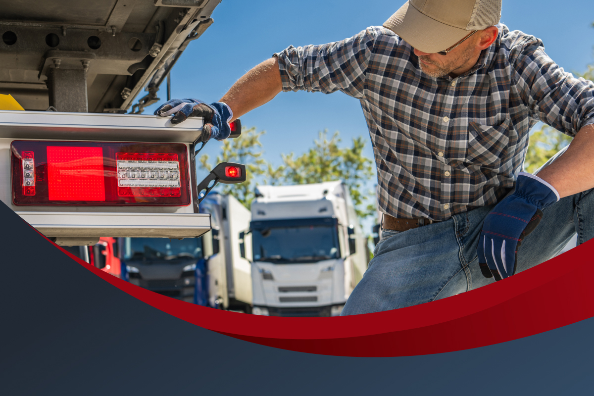 M man inspects the taillight of a tractor trailer. Peterbilt of Southern Alberta stands ready to inspect your truck and ensure its performance for years to come.