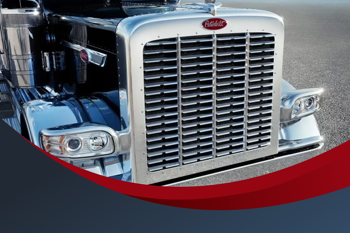 A Peterbilt truck sits ready to roll in a parking lot.